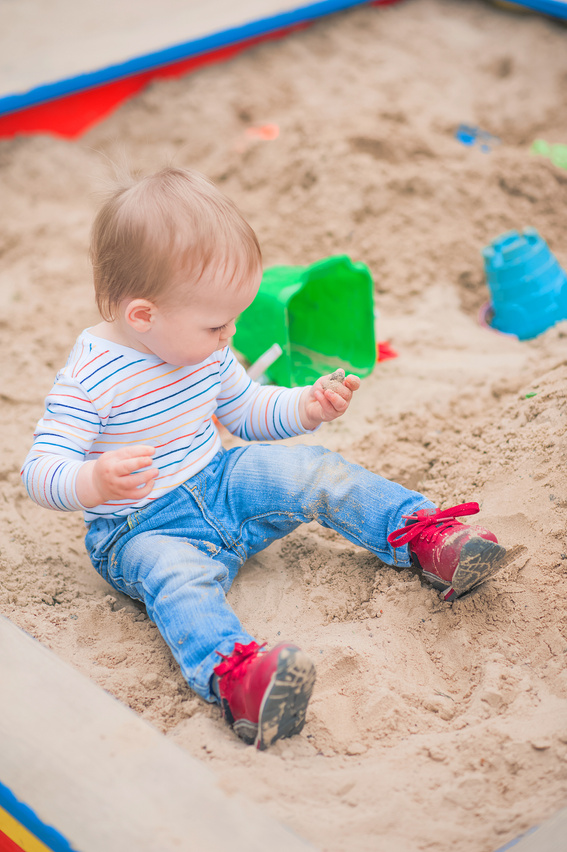 Toddler activity on playground in sandbox..